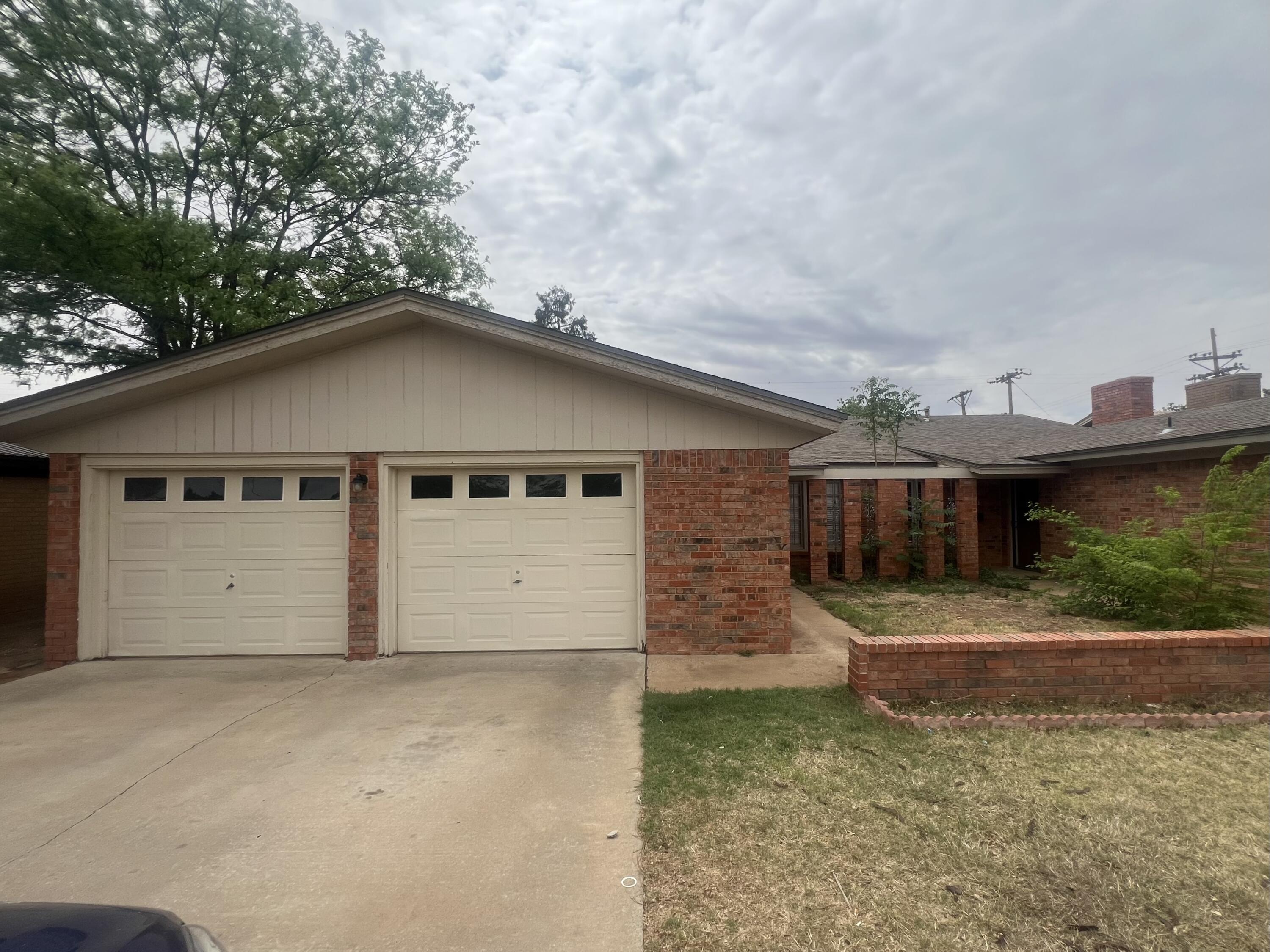 5113 13th Street, Unit A Lubbock, TX 79416 - Photo 1 of 25 a front view of a house with a yard