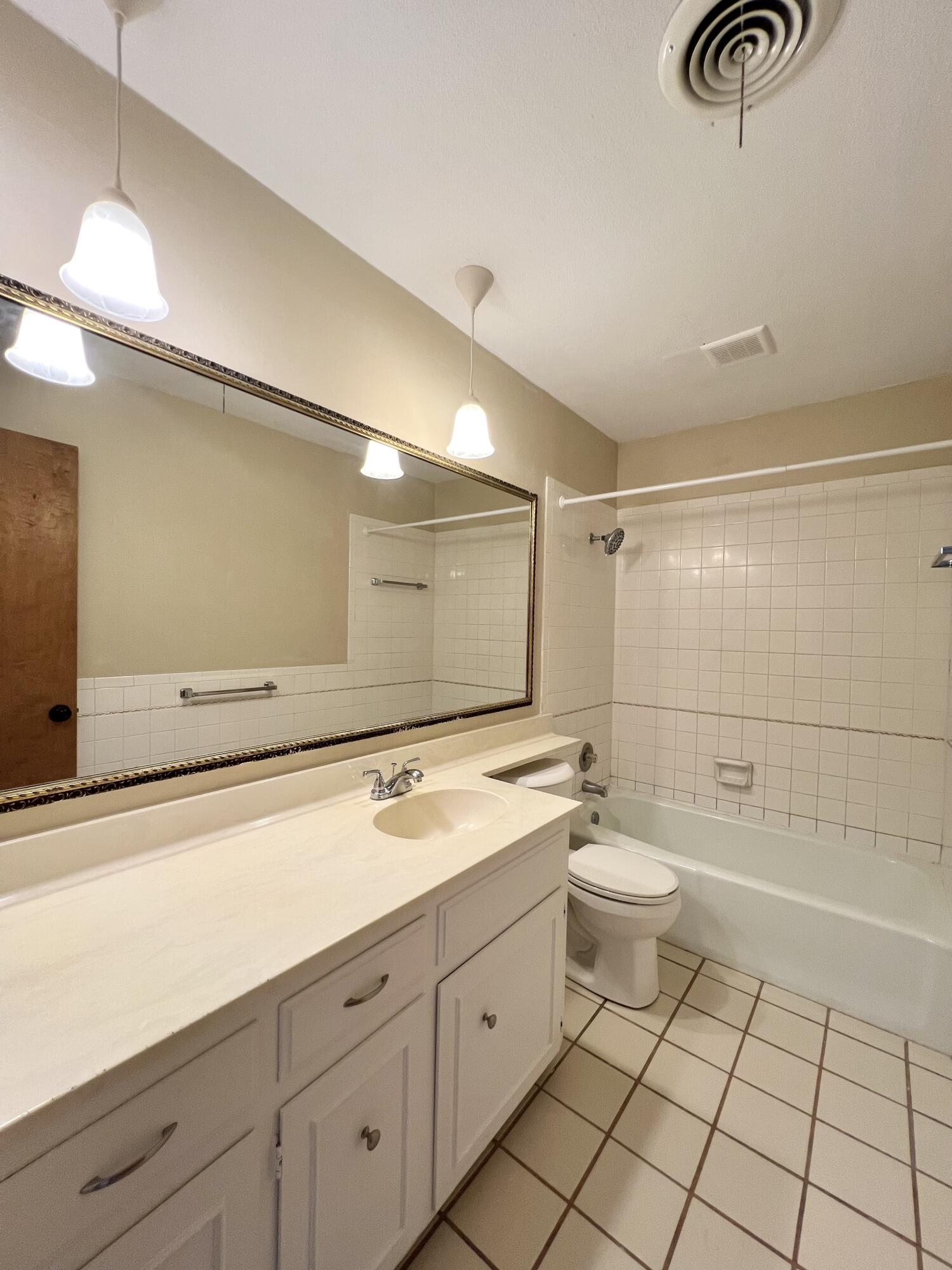 5113 13th Street, Unit A Lubbock, TX 79416 - Photo 11 of 25 a spacious bathroom with a shower a sink and a mirror