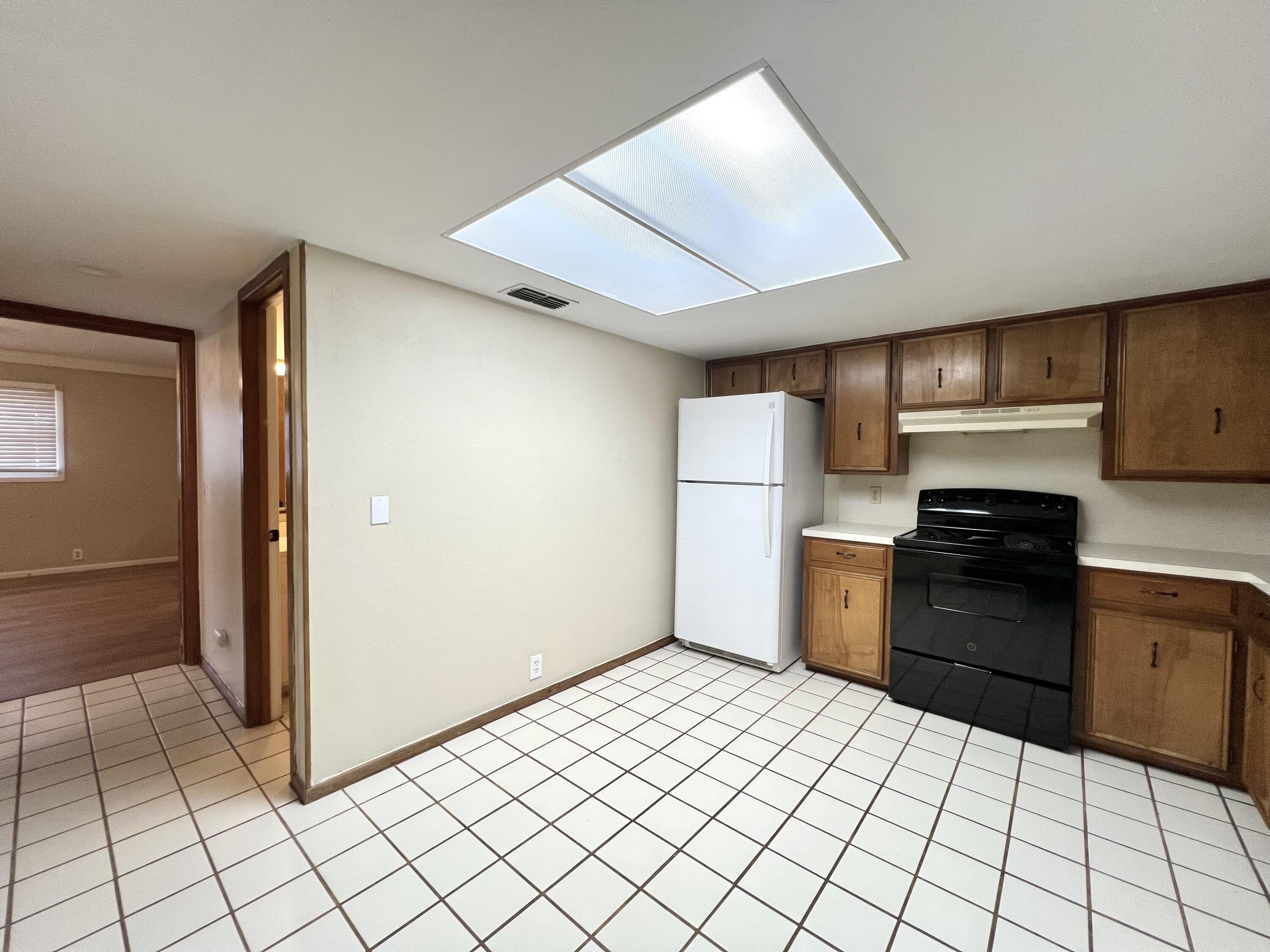 5113 13th Street, Unit A Lubbock, TX 79416 - Photo 13 of 25 a kitchen with granite countertop a refrigerator and a stove top oven