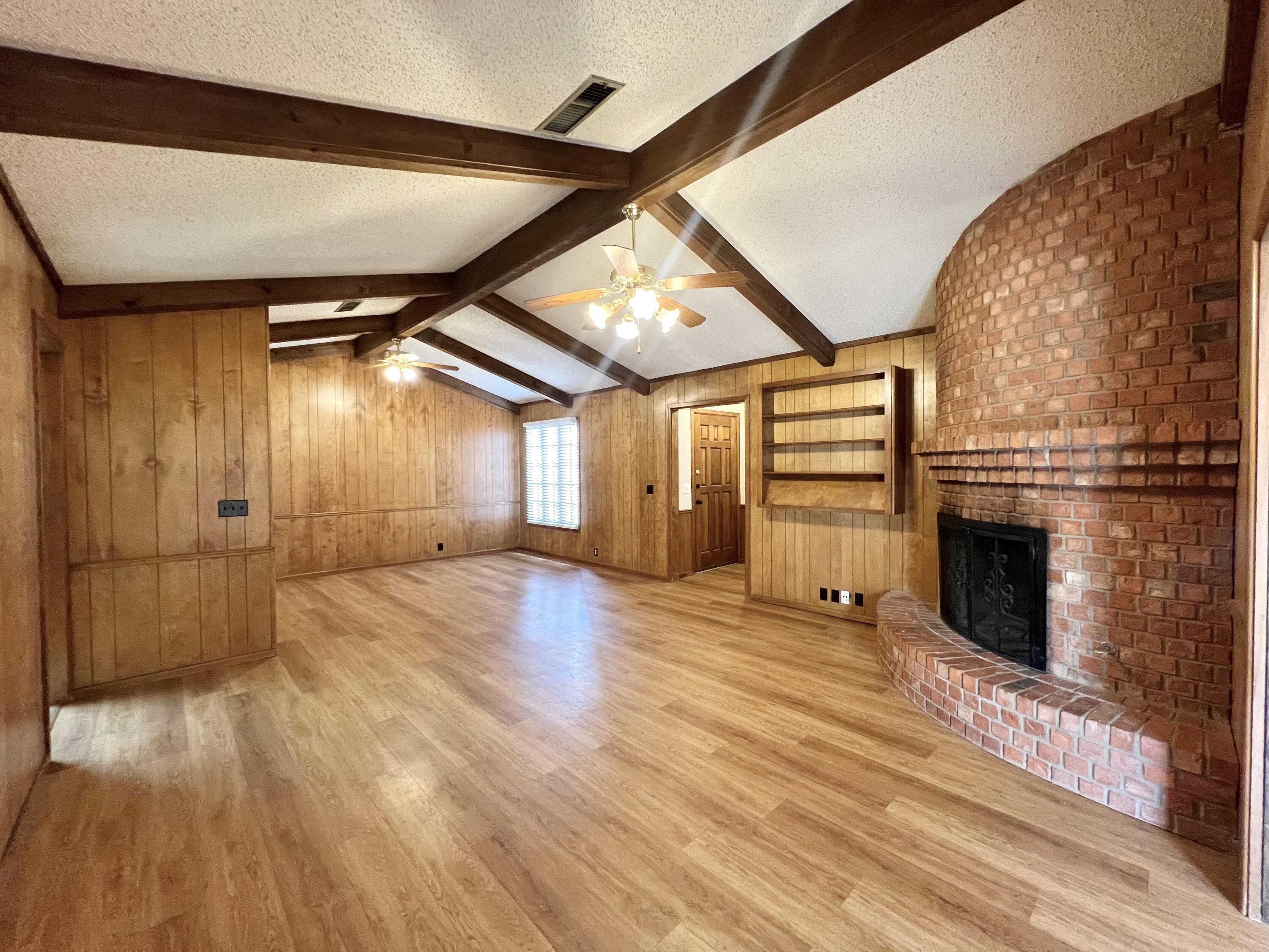 5113 13th Street, Unit A Lubbock, TX 79416 - Photo 19 of 25 en empty room with wooden floor fireplace and windows