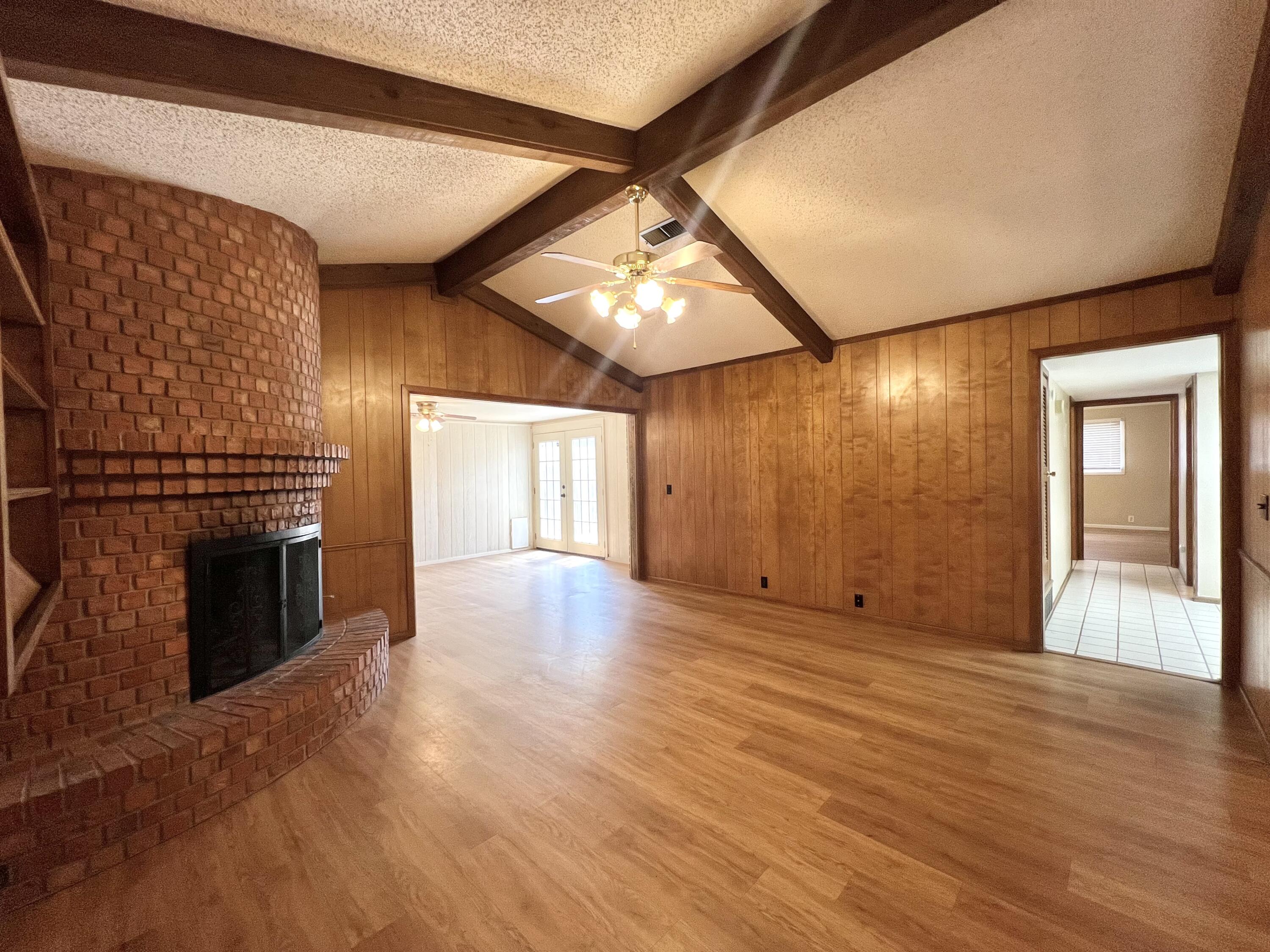 5113 13th Street, Unit A Lubbock, TX 79416 - Photo 22 of 25 a view of an empty room with wooden floor fireplace and a window