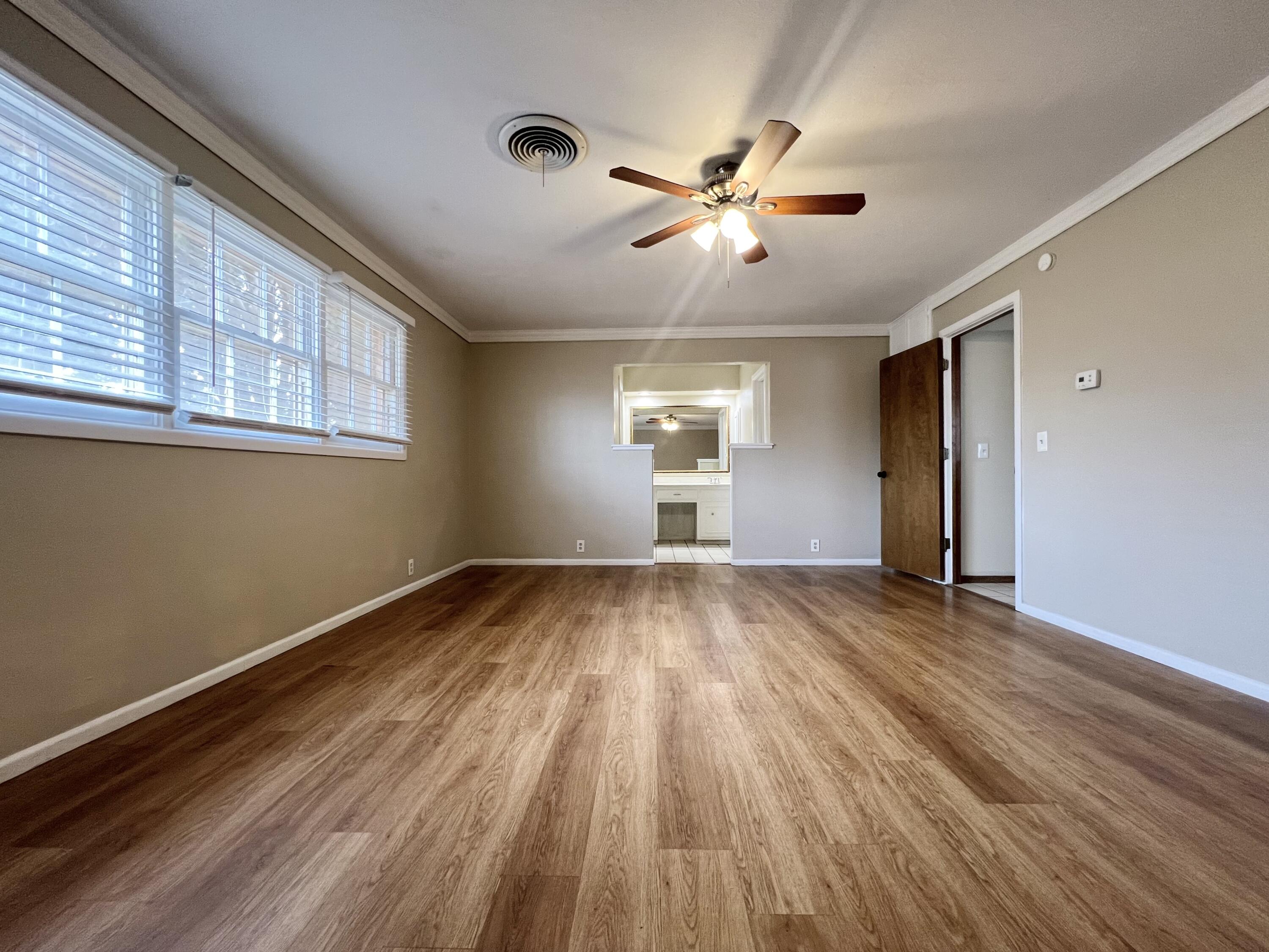 5113 13th Street, Unit A Lubbock, TX 79416 - Photo 8 of 25 a view of empty room with wooden floor and fan