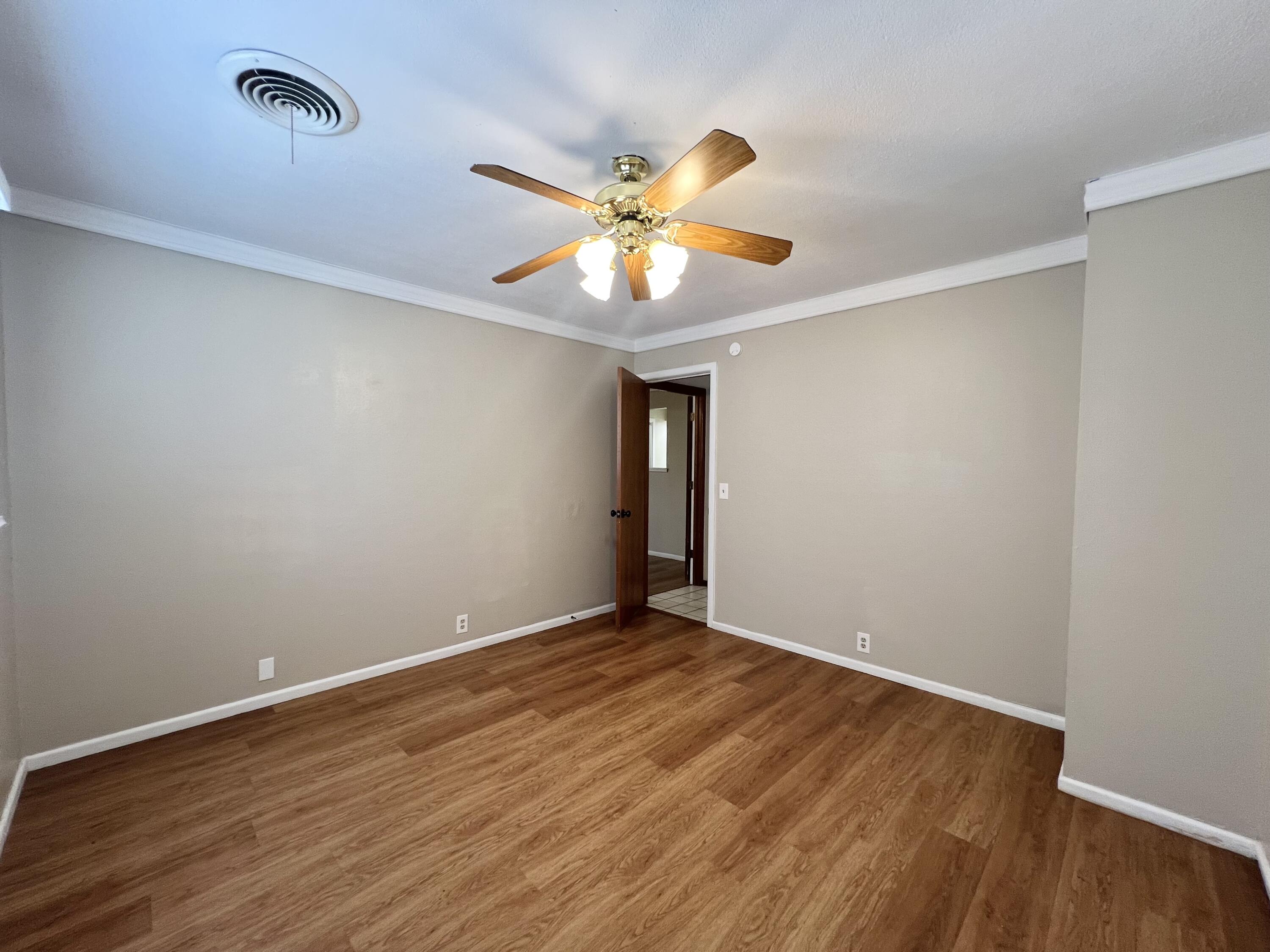 5113 13th Street, Unit A Lubbock, TX 79416 - Photo 9 of 25 a view of an empty room with window and wooden floor