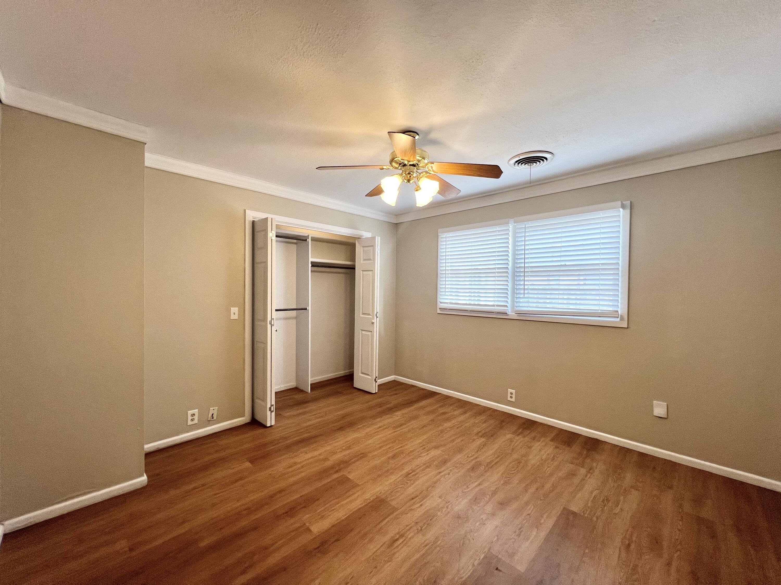 5113 13th Street, Unit A Lubbock, TX 79416 - Photo 10 of 25 a view of an empty room with wooden floor and a window