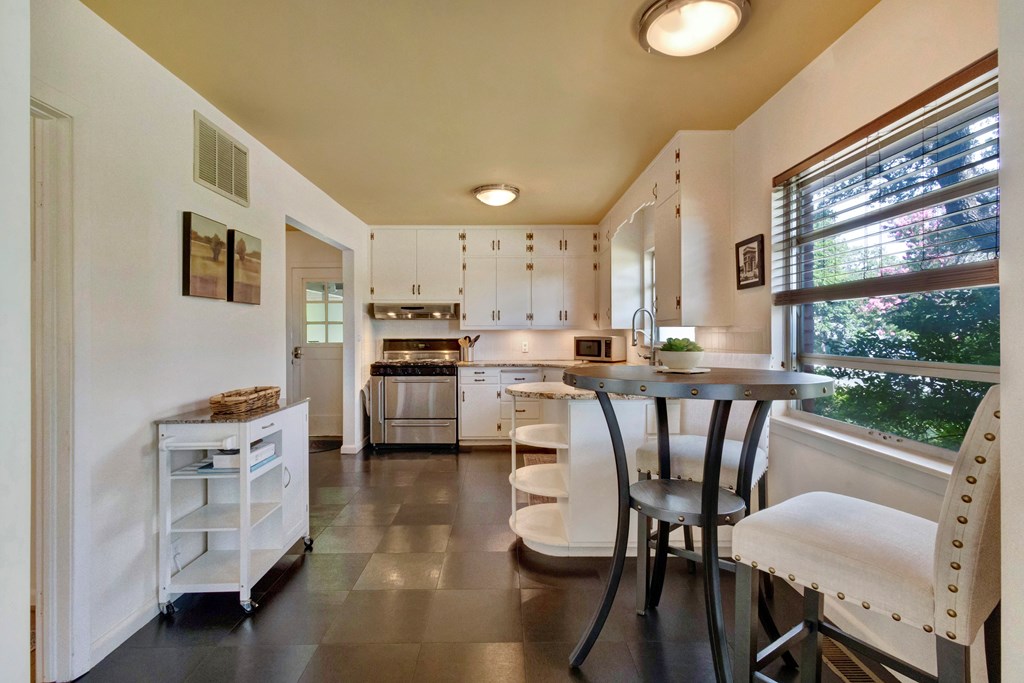 207 East Walnut Street Fredericksburg, TX 78624 - Photo 15 of 42 a kitchen with a table chairs wooden floors and white stainless steel appliances