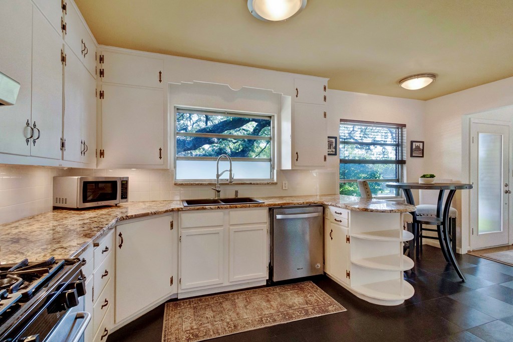 207 East Walnut Street Fredericksburg, TX 78624 - Photo 17 of 42 a kitchen with stainless steel appliances granite countertop a sink stove and cabinets