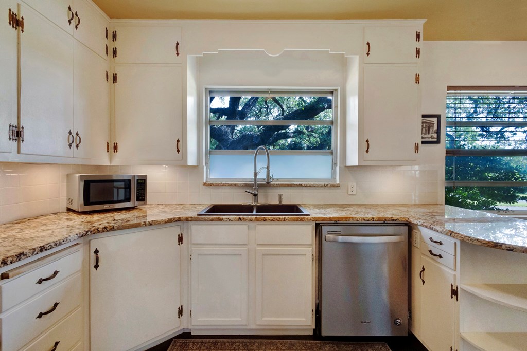 207 East Walnut Street Fredericksburg, TX 78624 - Photo 19 of 42 a kitchen with granite countertop white cabinets and white appliances