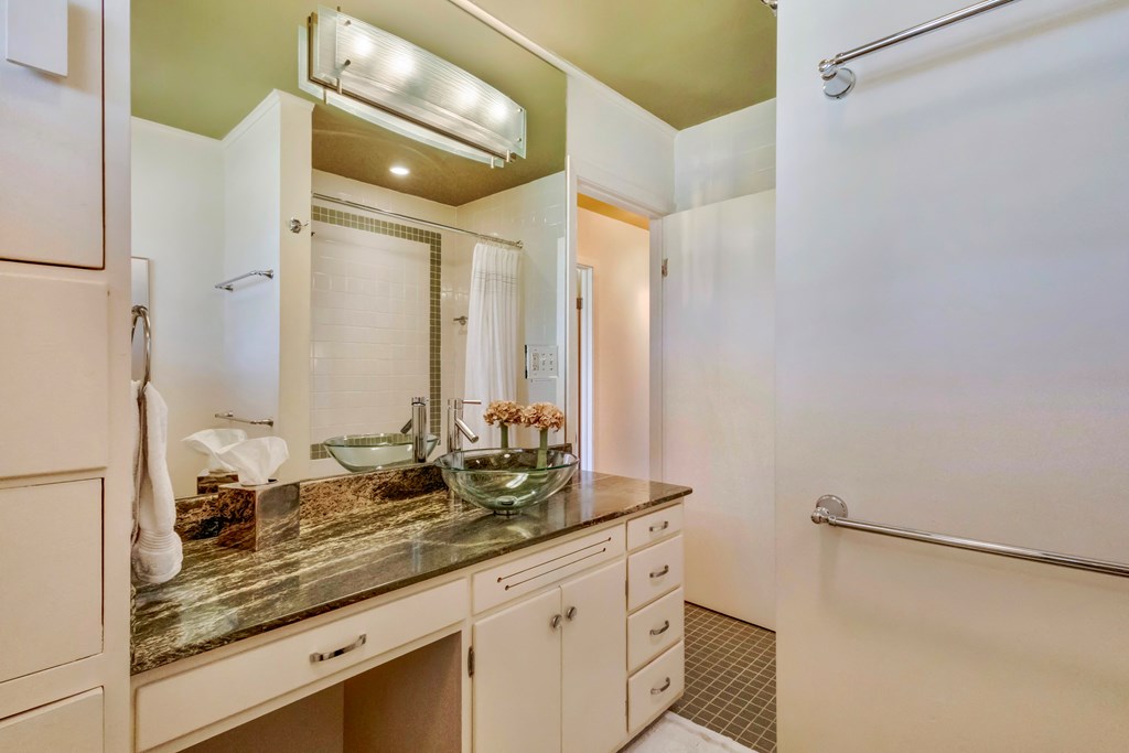 207 East Walnut Street Fredericksburg, TX 78624 - Photo 27 of 42 a bathroom with a granite countertop sink and a mirror