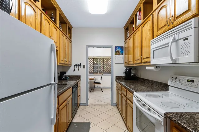 a kitchen with granite countertop a sink a counter top space and cabinets