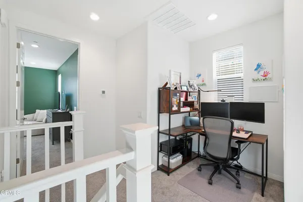 a view of a workspace with furniture and a window