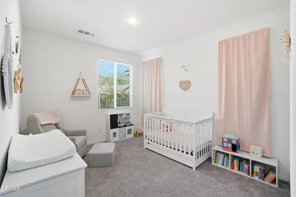 a living room with furniture a baby crib and a window