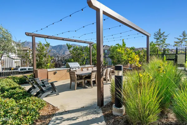 a view of a patio with table and chairs potted plants and floor to ceiling window