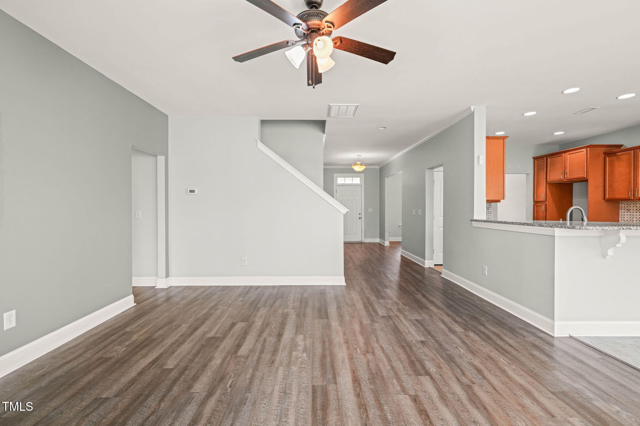4508 Brintons Cottage Street Raleigh, NC 27616 - Photo 6 of 46 a view of a room with wooden floor a ceiling fan and staircase