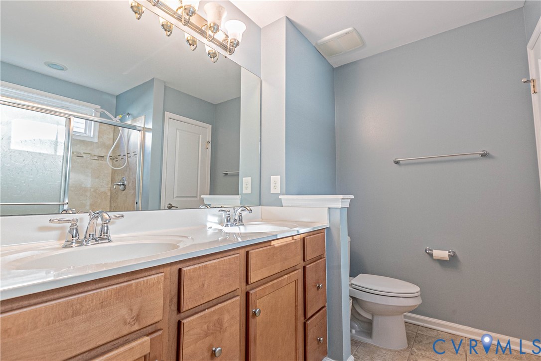 7533 South Franklins Way Quinton, VA 23141 - Photo 32 of 46 a bathroom with a double vanity sink toilet and a mirror