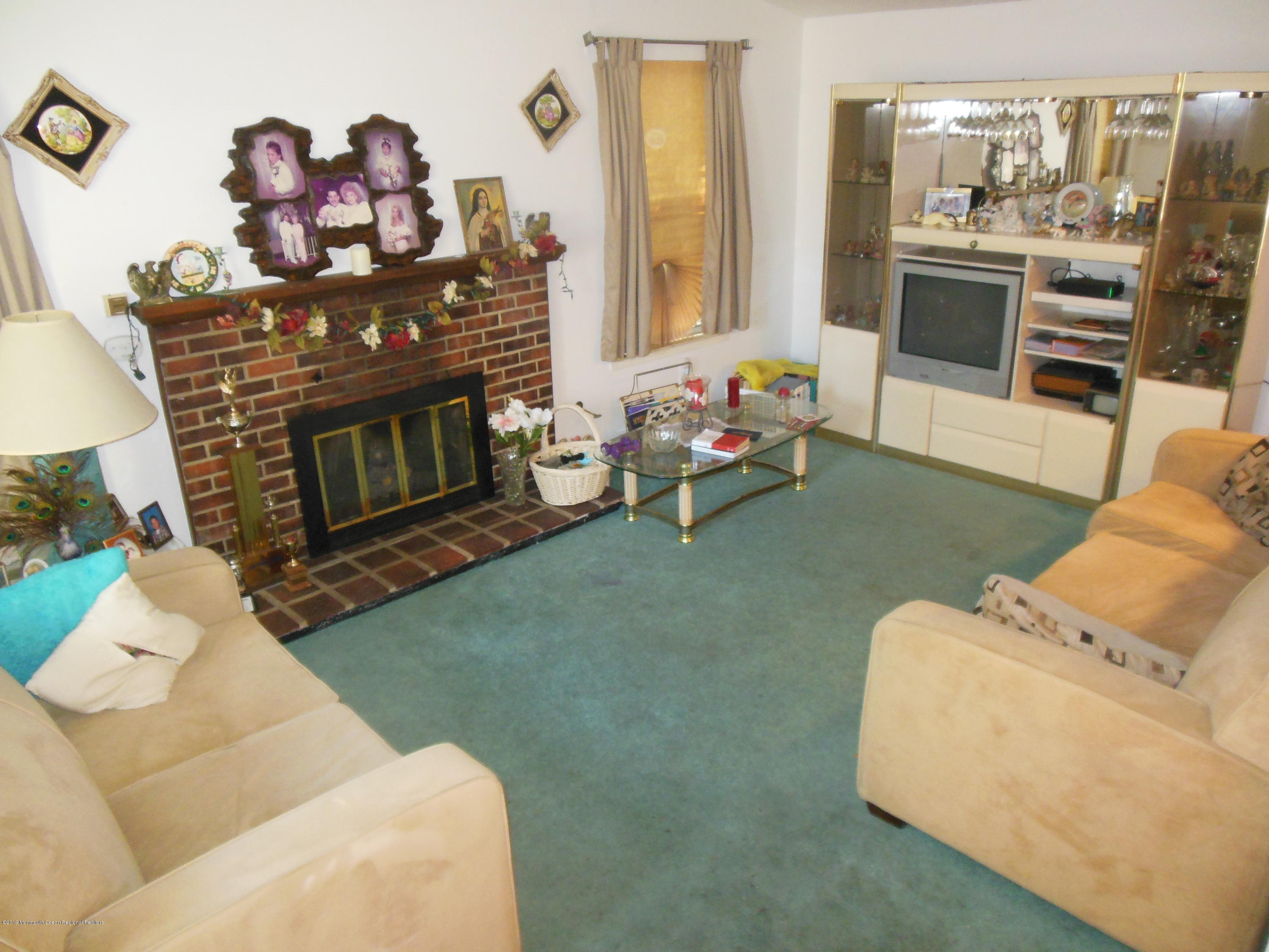 859 Radio Road Little Egg Harbor, NJ 08087 - Photo 8 of 17 a living room with furniture a flat screen tv and a fireplace