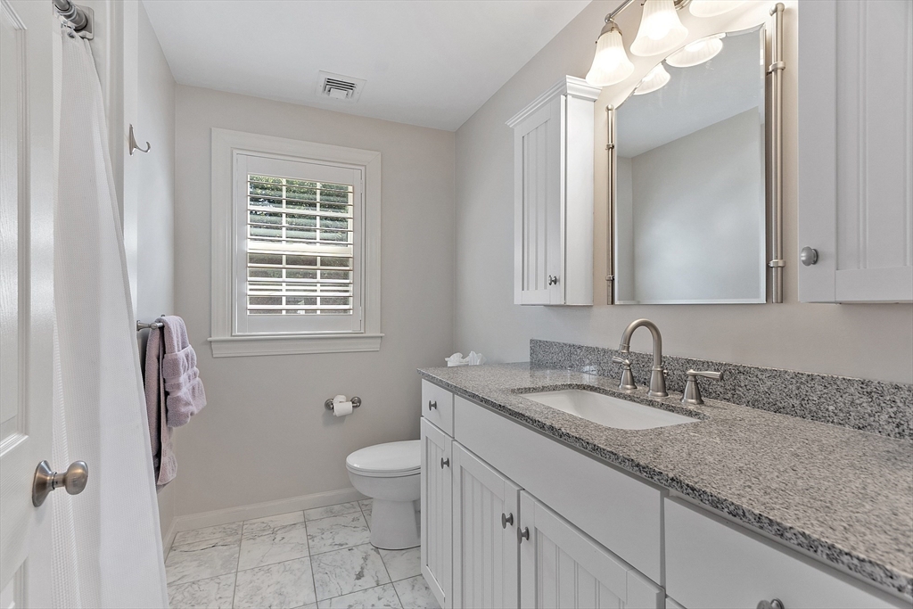 18 Sycamore Road Shrewsbury, MA 01545 - Photo 21 of 40 a bathroom with a granite countertop sink a toilet and a mirror