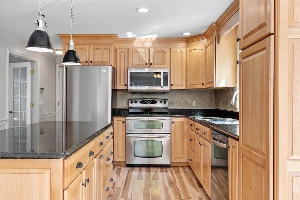18 Sycamore Road Shrewsbury, MA 01545 - Photo 4 of 40 a kitchen with granite countertop a refrigerator stove and sink