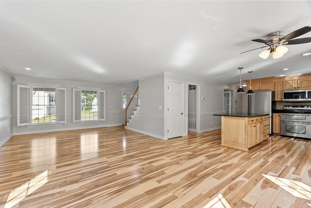 18 Sycamore Road Shrewsbury, MA 01545 - Photo 8 of 40 a view of a kitchen with kitchen island wooden floors appliances and living room
