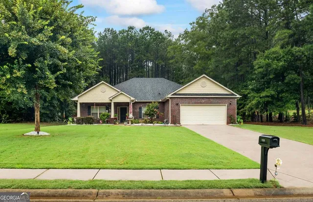 a front view of a house with a yard and trees