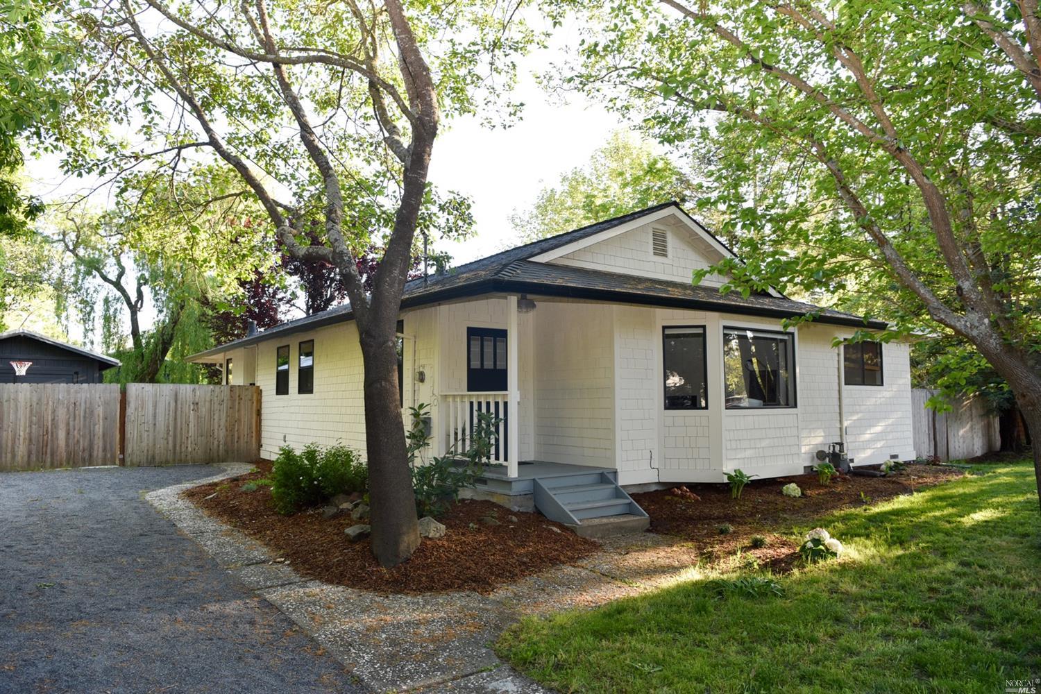a front view of house with yard and trees around