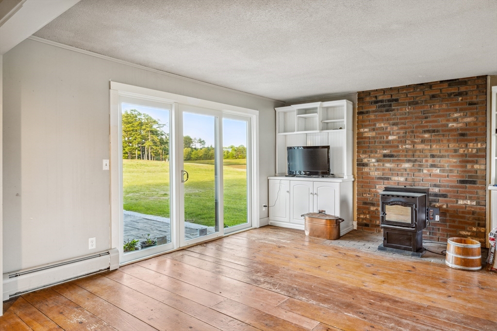 79 Wapping Road Kingston, MA 02364 - Photo 5 of 19 a view of livingroom with furniture flat screen tv and floor to ceiling window