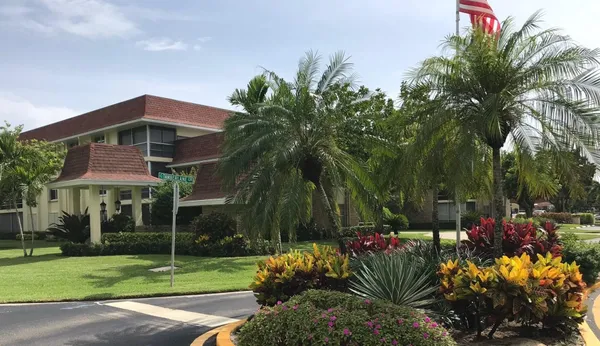 a group of people sitting in a yard with swimming pool