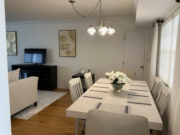 a view of a dining room with furniture and a chandelier