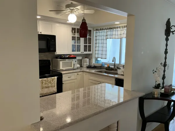a kitchen with a sink a stove and chairs