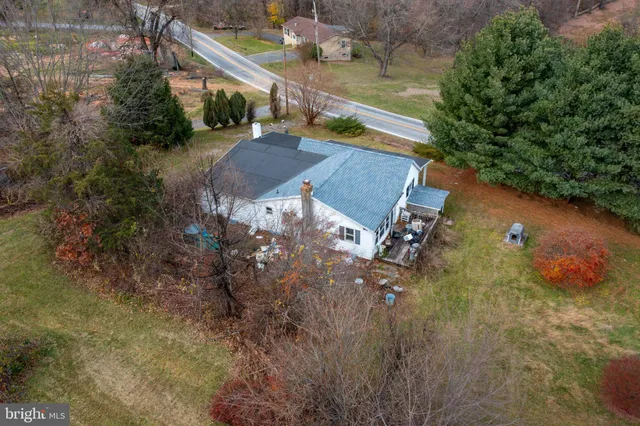 a aerial view of a house with table and chairs under an umbrella