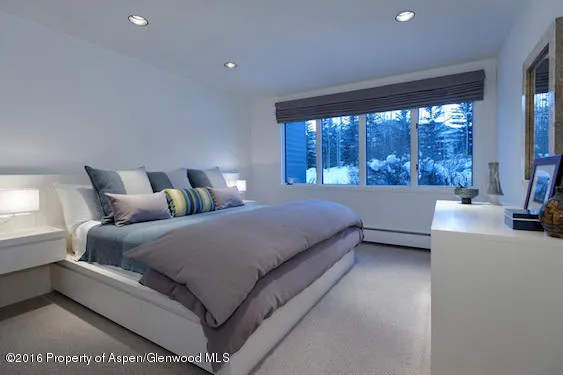 a bed room with a bed and a large window