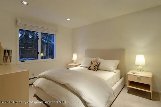 a bedroom with a bed and a night stand