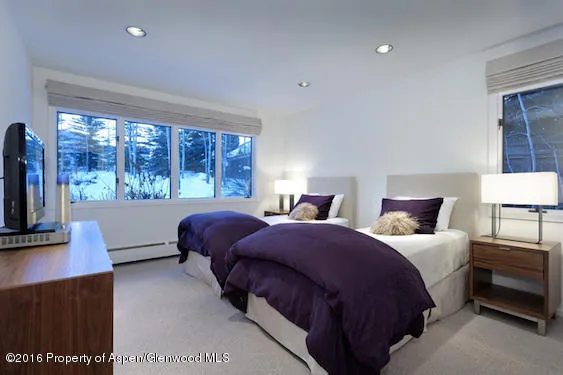 a bedroom with two beds and a night stand