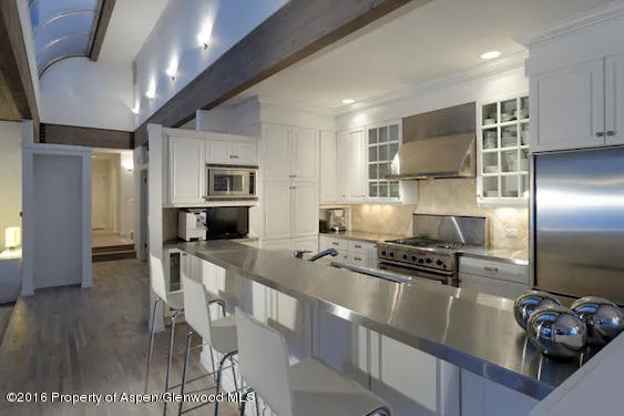 a kitchen with stainless steel appliances granite countertop a stove refrigerator and a sink
