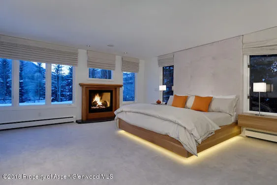 a spacious bedroom with a bed and a fireplace