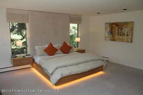 a bed sitting in a bedroom next to a window