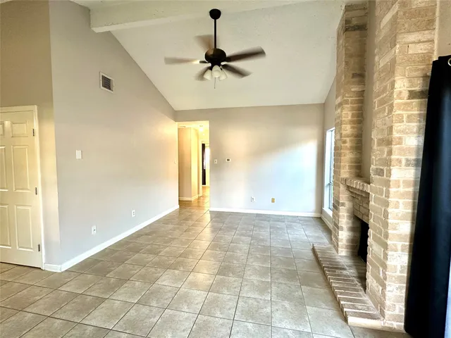 a view of a hallway with a chandelier fan and windows