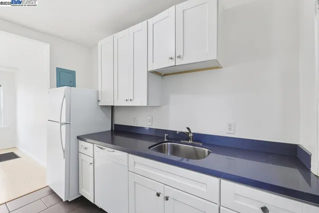 a kitchen with stainless steel appliances granite countertop white cabinets and a sink