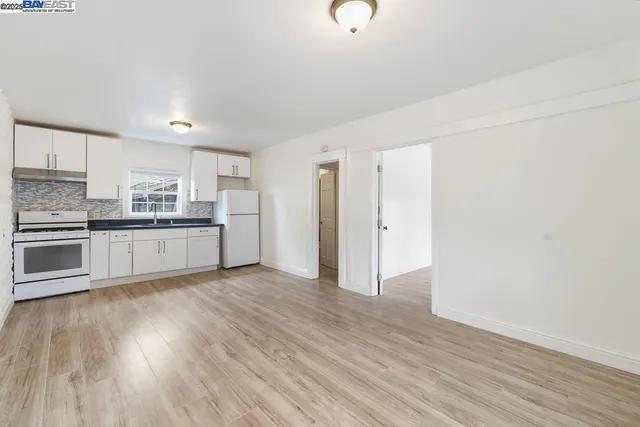 a kitchen with granite countertop white cabinets and white appliances