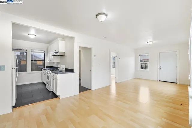 a view of a kitchen with refrigerator stove and wooden floor