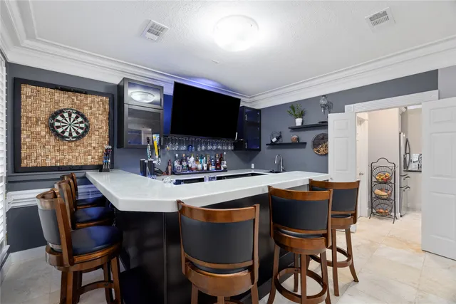 a kitchen with stainless steel appliances a sink a stove a microwave cabinets and a dining table