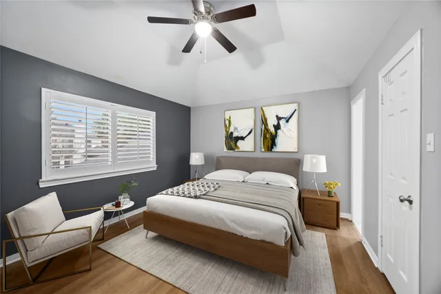 a bedroom with a bed couch tv and a window