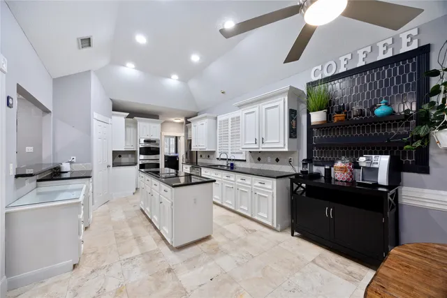 a kitchen with stainless steel appliances granite countertop a sink stove and cabinets