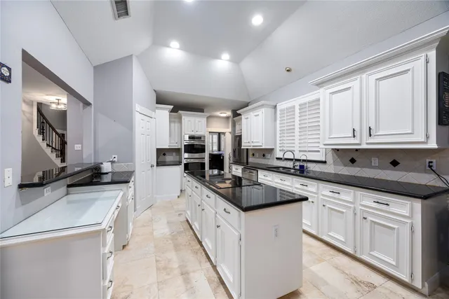 a kitchen with stainless steel appliances kitchen island granite countertop a sink and cabinets