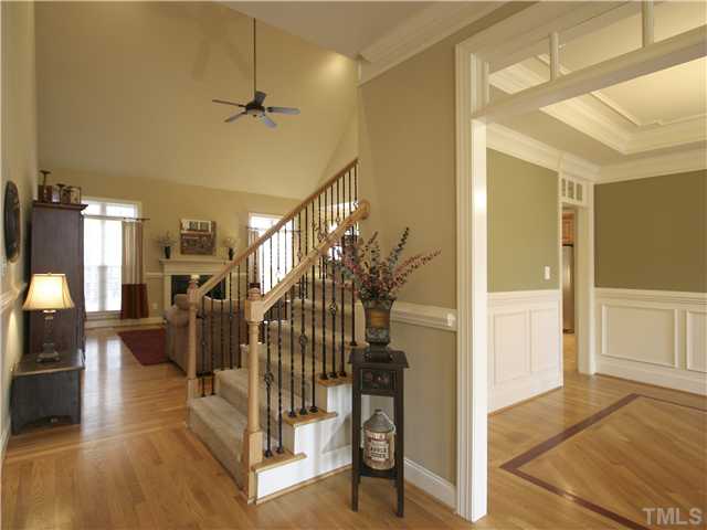 1200 Verde Farm Road Raleigh, NC 27603 - Photo 5 of 25 Staircase is conveniently located in the center of the home. Wrought-iron pickets. Note dining room to the right has transoms over openings to foyer and kitchen. Inlaid wood floor.