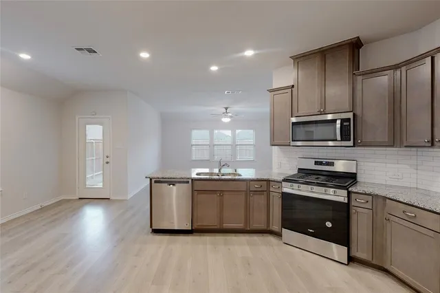 a kitchen with granite countertop a stove top oven and cabinets