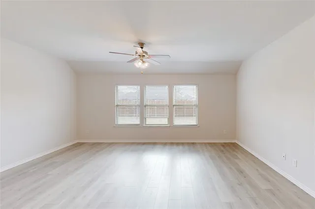 a view of an empty room with a ceiling fan