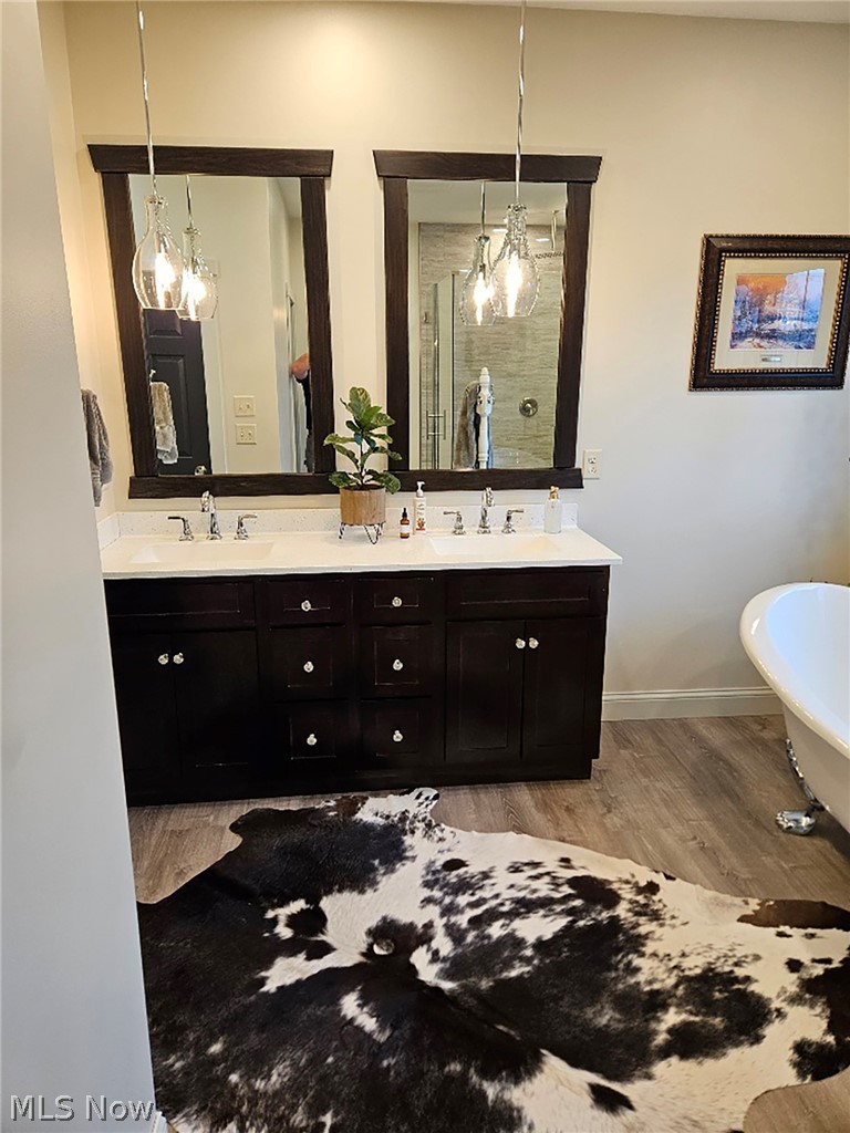 25073 Ridge Road East Rochester, OH 44625 - Photo 32 of 37 Bathroom with a chandelier, dual vanity, a bath, and wood-type flooring
