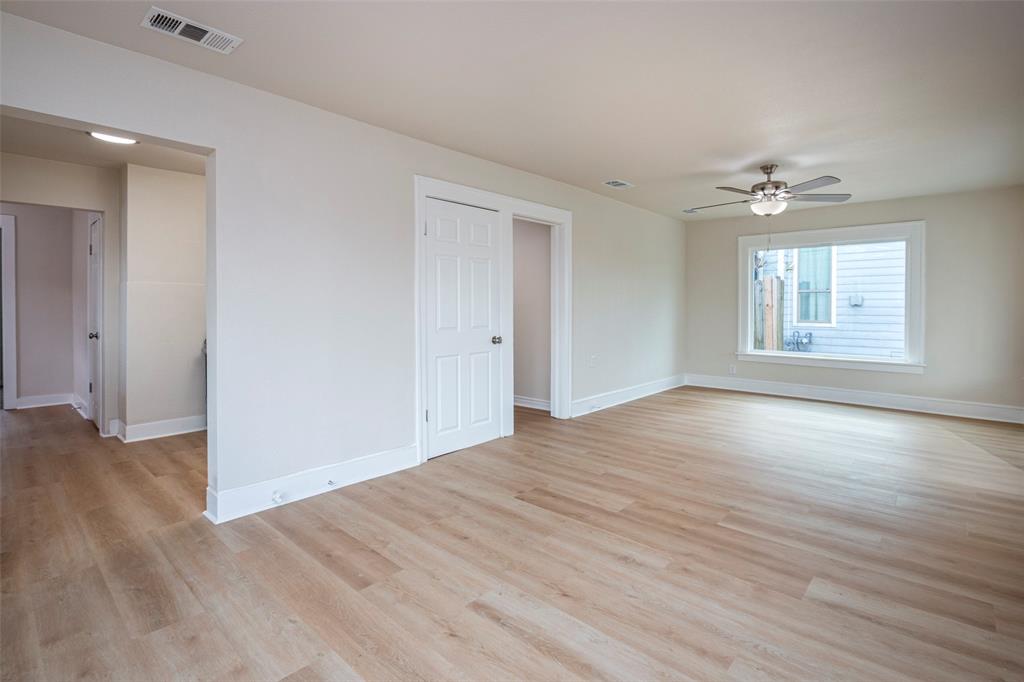 628 South Westmoreland Road Dallas, TX 75211 - Photo 4 of 19 an empty room with wooden floor ceiling fan and windows