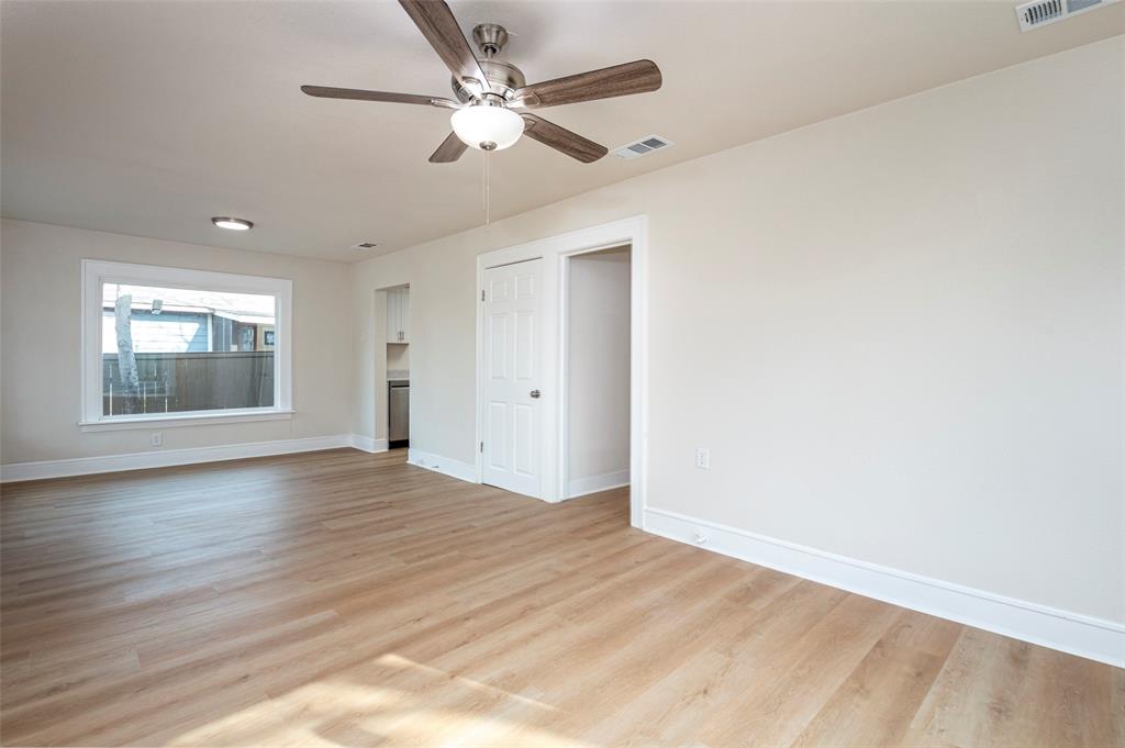 628 South Westmoreland Road Dallas, TX 75211 - Photo 5 of 19 an empty room with wooden floor chandelier fan and windows
