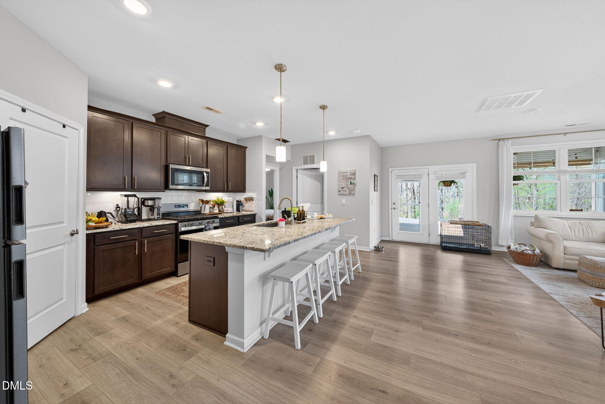 1519 Nichols Crk Road Durham, NC 27703 - Photo 10 of 22 a kitchen with stainless steel appliances kitchen island granite countertop a stove top oven a sink a refrigerator and white cabinets